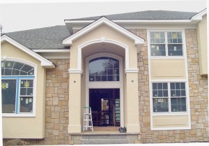 Custom column entrance with arched trim.  Raised stucco panel detail at windows.