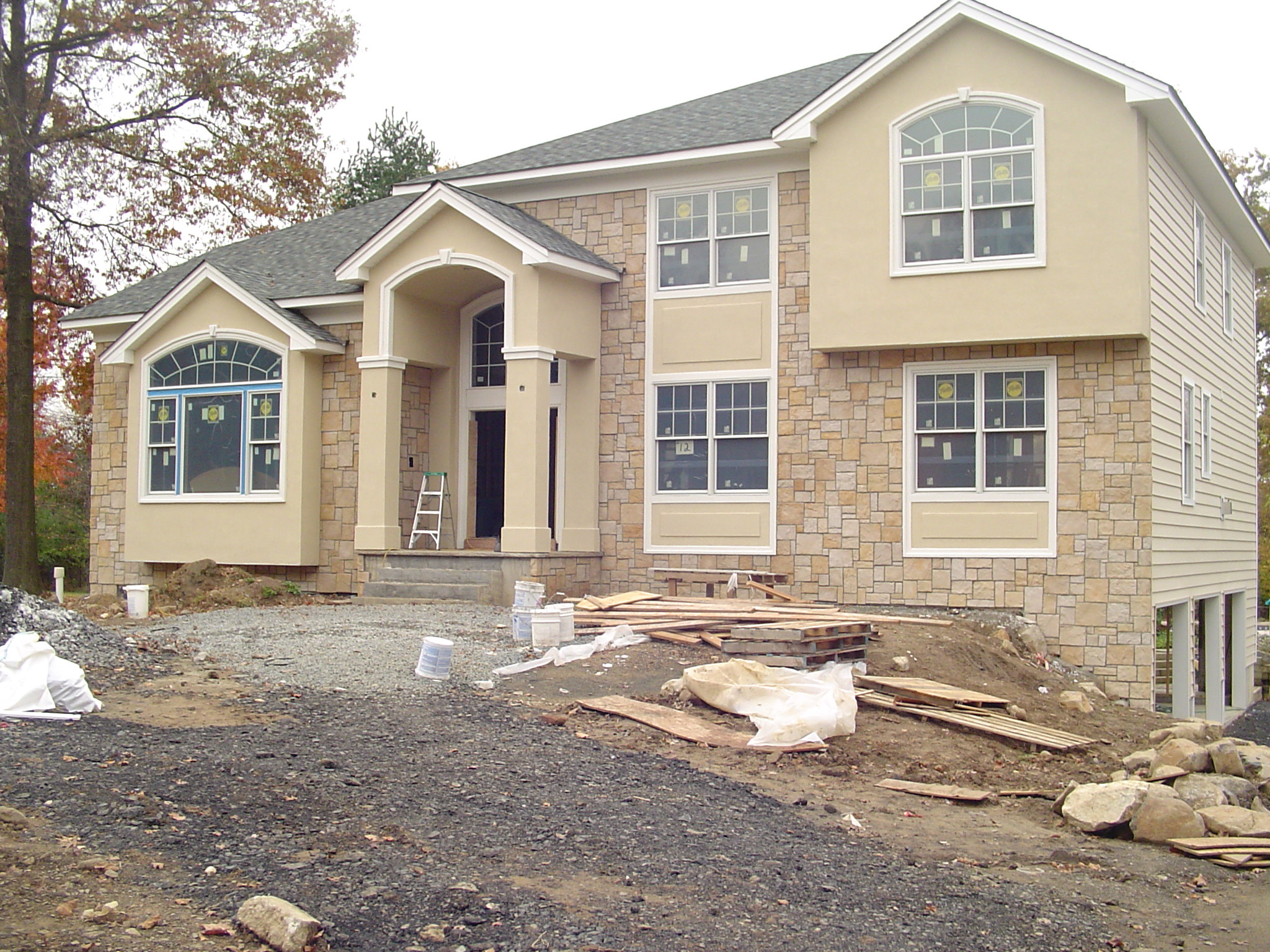 Custom home Essex County after completion of stucco front with stone and custom trim detail.